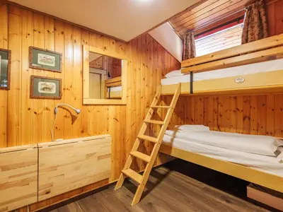 a bunk room with two bunk beds and a ladder at Apartment Boiserie by Interhome in Campitello di Fassa