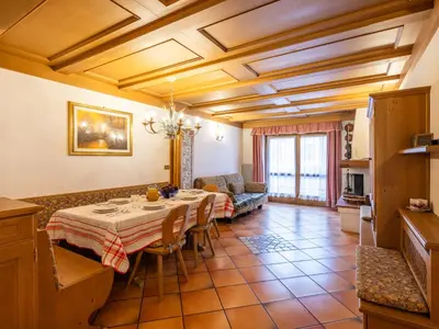 a kitchen and living room with a table and a couch at Apartment Corte dei Larici by Interhome in Campitello di Fassa