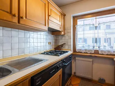 a kitchen with a stove top oven next to a window at Apartment Corte dei Larici by Interhome in Campitello di Fassa