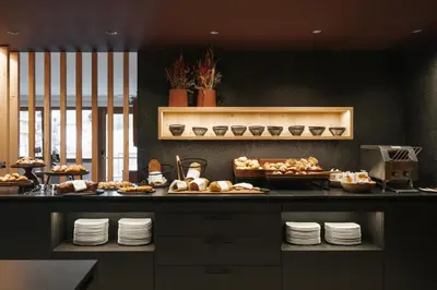 a kitchen with a counter with bread and pastries at Brunelle Seiser Alm Lodge in Alpe di Siusi