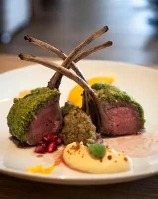 a plate of food with steak on a table at Brunelle Seiser Alm Lodge in Alpe di Siusi