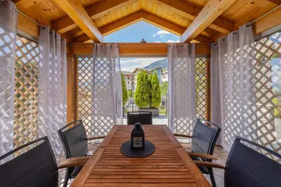 a wooden table and chairs on a screened in porch at Villa Azzurra, Cloz Ospitar in Cloz