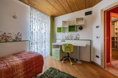 a bedroom with a desk and a bed and a chair at Villa Azzurra, Cloz Ospitar in Cloz