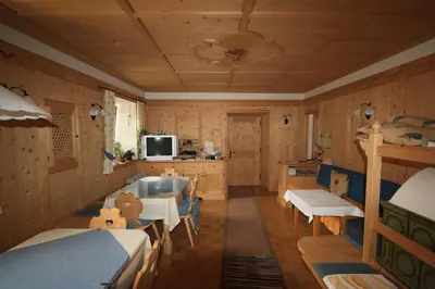 a room with a bedroom with a tub and a tv at Haus Schmiedhofer in Villabassa