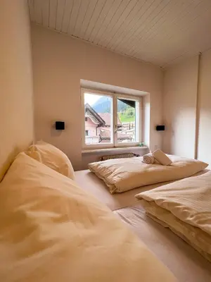 two beds in a room with a window at Lovely,cosy Apartment 2 Min Skilift Walk in Campitello di Fassa