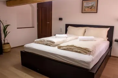 a large bed with white sheets and pillows on it at Lovely,cosy Apartment 2 Min Skilift Walk in Campitello di Fassa