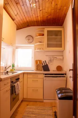 a kitchen with white appliances and a wooden ceiling at Lovely,cosy Apartment 2 Min Skilift Walk in Campitello di Fassa