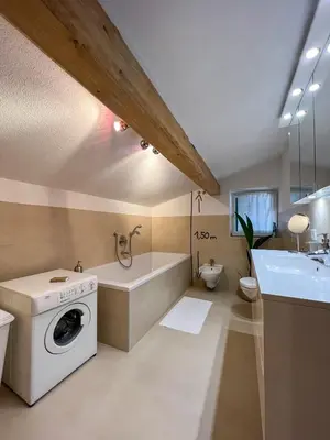 a bathroom with a washing machine and a bath tub at Lovely,cosy Apartment 2 Min Skilift Walk in Campitello di Fassa