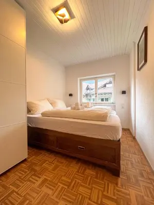 a bedroom with a large bed with a window at Lovely,cosy Apartment 2 Min Skilift Walk in Campitello di Fassa