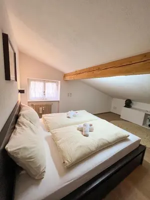 a large white bed with two towels on it at Lovely,cosy Apartment 2 Min Skilift Walk in Campitello di Fassa