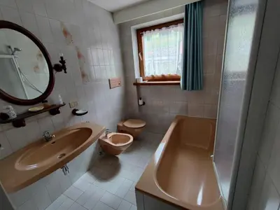 a bathroom with a tub and a toilet and a sink at Garofol da Mont-Dolomiti e Relax in Soraga