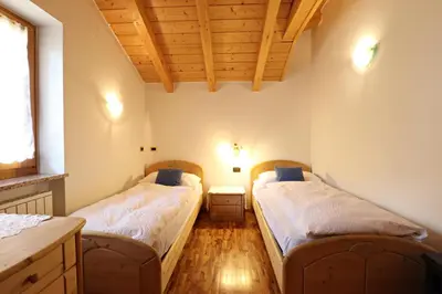 two beds in a room with a wooden ceiling at Casa mia - vall di fassa in Vigo di Fassa
