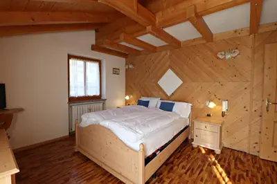 a bedroom with a large bed in a room with wooden ceilings at Casa mia - vall di fassa in Vigo di Fassa