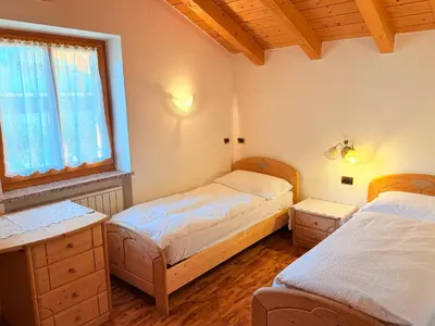 a bedroom with two beds and a window at Casa mia - vall di fassa in Vigo di Fassa