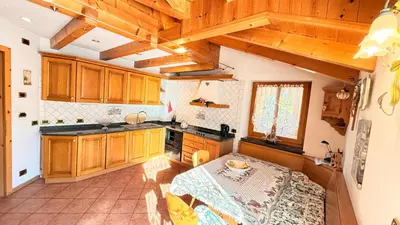a kitchen with wooden cabinets and a table in it at Casa mia - vall di fassa in Vigo di Fassa