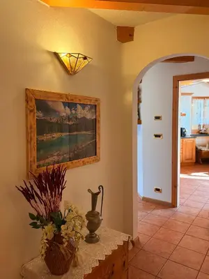 a hallway with a vase and a painting on the wall at Casa mia - vall di fassa in Vigo di Fassa