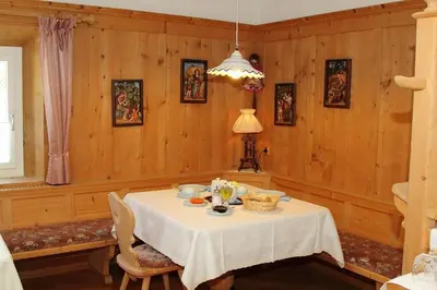 a dining room with a table with a white table cloth at Bed and Breakfast Iman in Santa Cristina in Val Gardena