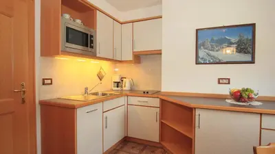 a small kitchen with white cabinets and a sink at Bed and Breakfast Iman in Santa Cristina in Val Gardena
