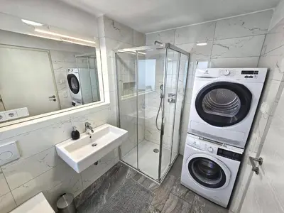 a bathroom with a washing machine and a sink at Apartment Rosmarin - Alpstay in Naturno