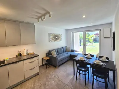 a kitchen and living room with a table and a couch at Apartment Rosmarin - Alpstay in Naturno