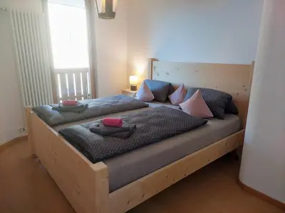 a wooden bed with pillows on it in a bedroom at Appartamento-Wohnung Amblar in Cavareno