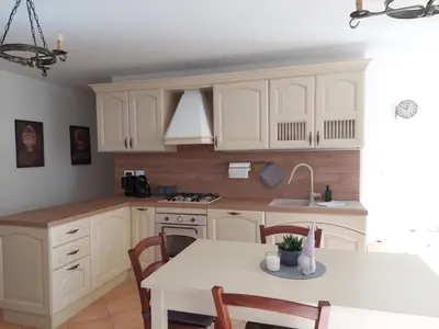 a kitchen with white cabinets and a table with chairs at Appartamento-Wohnung Amblar in Cavareno