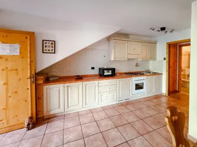 a kitchen with white cabinets and a microwave at Casa Massari in Campitello di Fassa