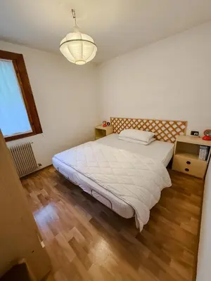 a bedroom with a large bed and a wooden floor at Casa Massari in Campitello di Fassa