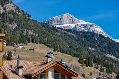 a house with a mountain in the background at Casa Massari in Campitello di Fassa