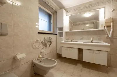 a bathroom with a toilet and a sink and a mirror at Casa Pini By Go new location in Moena
