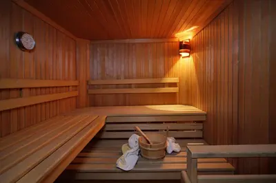 a wooden sauna with a bucket in it at Egger Apartments in Rifiano