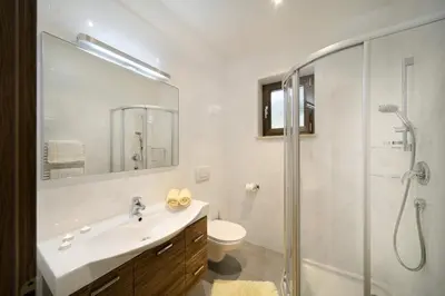 a bathroom with a sink and a shower and a toilet at Egger Apartments in Rifiano
