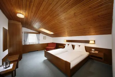 a bedroom with a large bed with a wooden ceiling at Egger Apartments in Rifiano