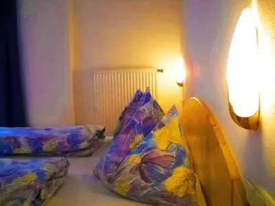 a room with two pillows on a bed with a lamp at Gasthof Hohenbichl in Terento