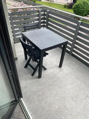 a black table and a chair on a balcony at Guest House Cemin in Predazzo