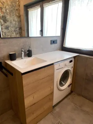 a bathroom with a sink and a washing machine at Guest House Cemin in Predazzo