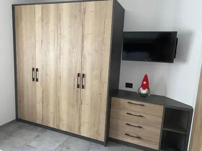 a large wooden cabinet with a tv on a wall at Guest House Cemin in Predazzo