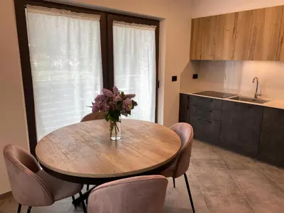 a kitchen with a table with a vase of flowers on it at Guest House Cemin in Predazzo