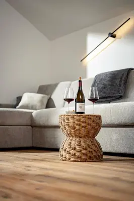 a bottle of wine and two glasses on a table in a living room at Untermoserhof in Bolzano