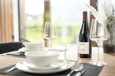 a table with a bottle of wine and glasses at Untermoserhof in Bolzano