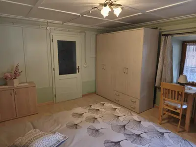 a living room with a table and a door and a room with a tableablish at Casa Roberta in Falcade