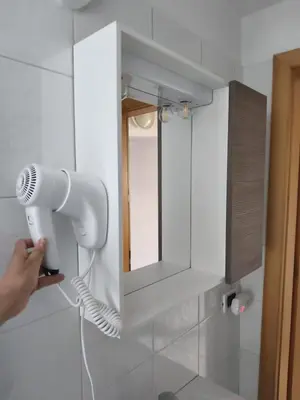 a person is holding a blow dryer in a bathroom at Casa Roberta in Falcade