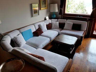 a living room with a couch and a table at Mansarda in chalet a Cortina in Cortina dʼAmpezzo