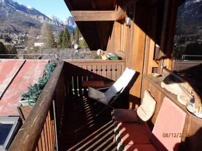 a balcony with a chair and a view of a mountain at Mansarda in chalet a Cortina in Cortina dʼAmpezzo