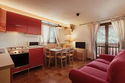 a kitchen and living room with a couch and a table at Stella Due in Arabba