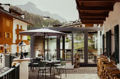 a patio with a table and chairs and an umbrella at Stella Due in Arabba