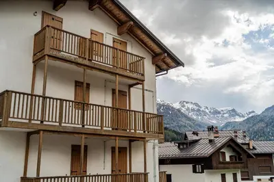 a balcony with a chair and a view of a street at The Cutie Of Dolomites in Falcade