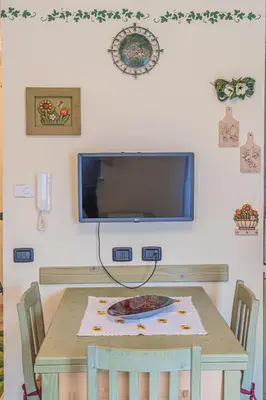 a table with a television on a wall with a plate on it at The Cutie Of Dolomites in Falcade