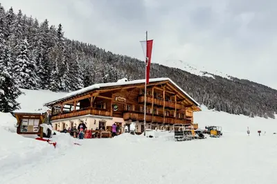 a log cabin in the snow with a red flag at Grossberghütte in Maranza