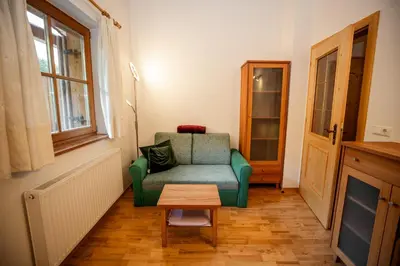 a living room with a green chair and a table at Grossberghütte in Maranza